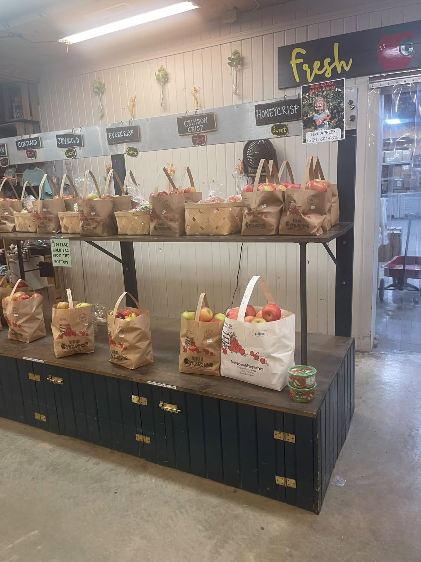 Bags of fresh apples in many varieties on the shelf at Curtis Orchard