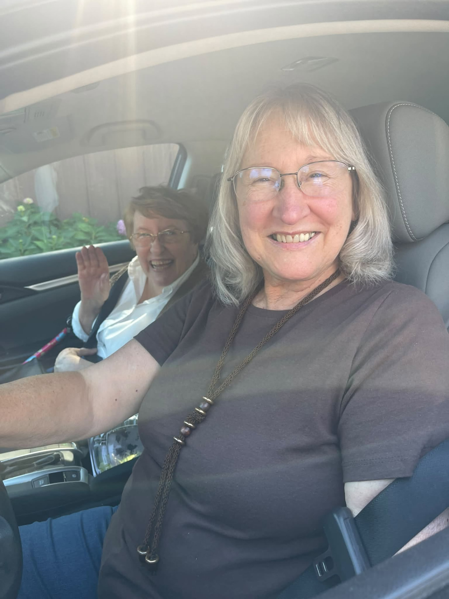 Two Xi Chapter members smiling in the car on the way to Curtis Orchard